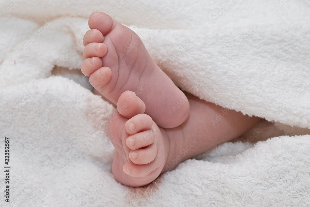 White towel around cute newborn feet White towel around cute newborn feet