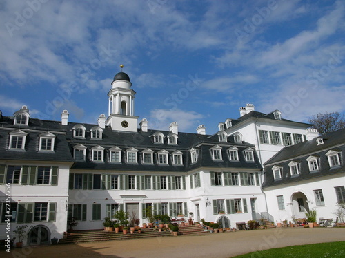 Schloss Rumpenheim mit Ehrenhof bei Sonnenschein und blauem Himmel mit Wölkchen im Stadtteil Rumpenheim in Offenbach am Main in Hessen photo