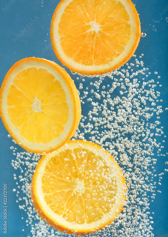 Fresh orange dropped into water with bubbles. Fresh orange dropped into water with bubbles.