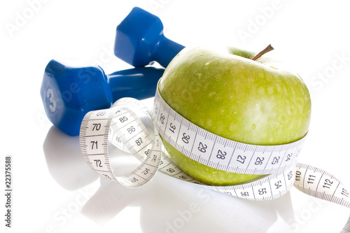 Dumbbells, green apple and measure tape isolated on white