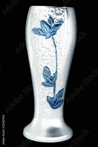 White vase with blue flower embossed on it against black