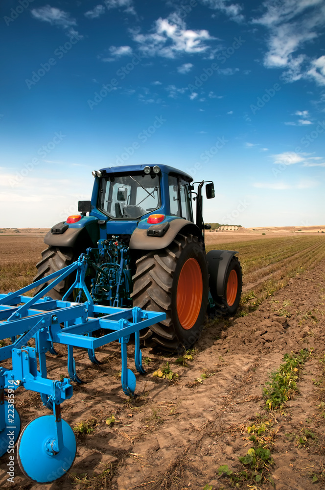Naklejka premium The Tractor - modern farm equipment in field