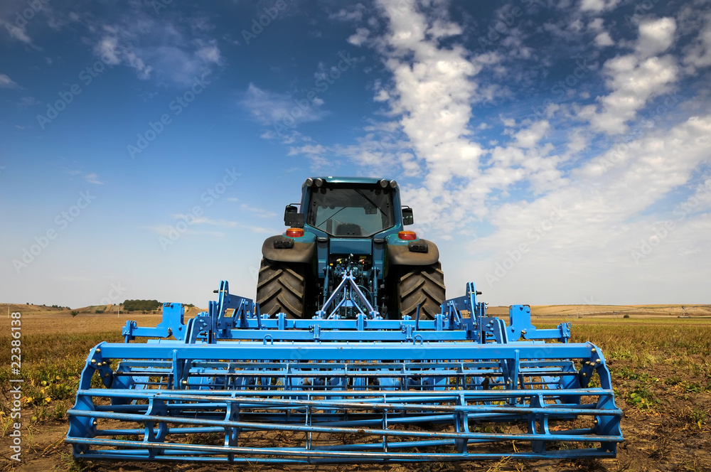 Naklejka premium The Tractor - modern farm equipment in field