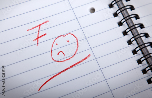 F grade and sad smilie written in a spiral pad
