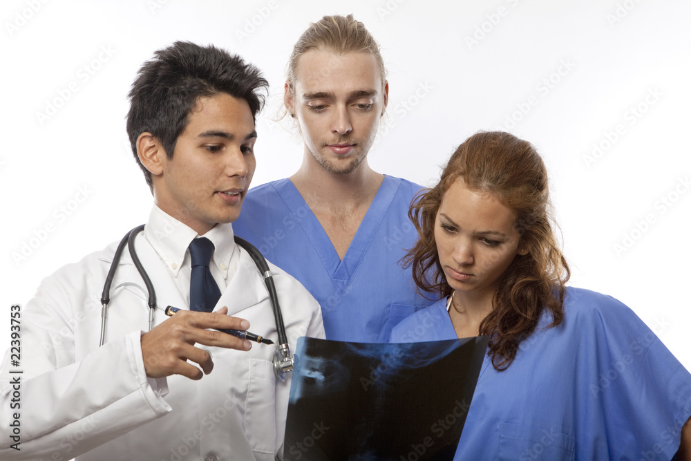 three medical students/interns/nurdses looking at an x-ray three medical students/interns/nurdses looking at an x-ray