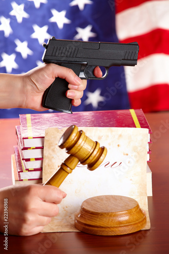 Hand with gun and judges gavel