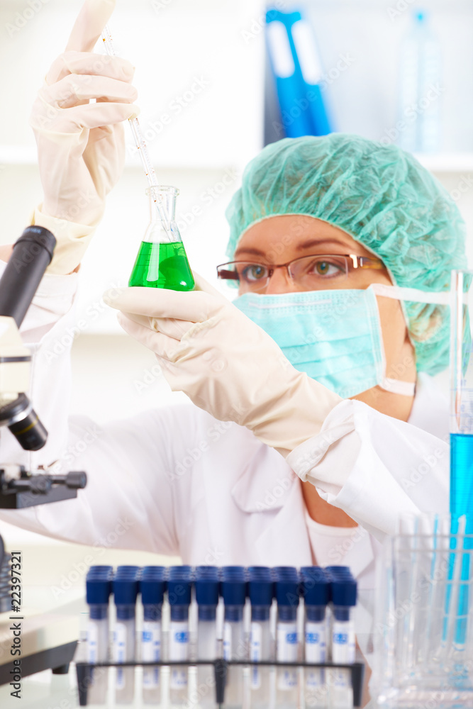 Researcher holding up a test tube and a retort