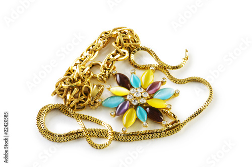 Golden chain and brooch isolated on white