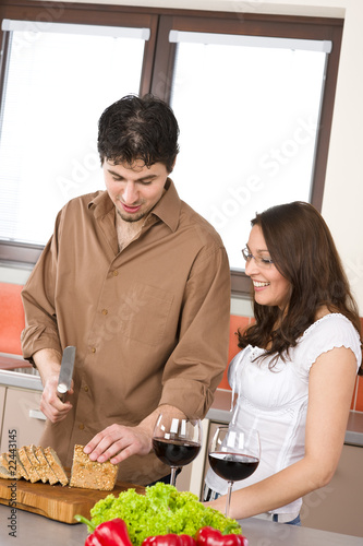 Happy couple cut bread in modern kitchen