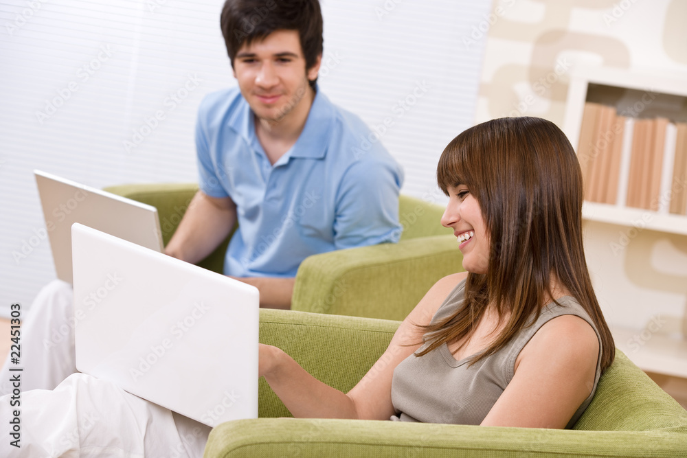 Student - two teenager with laptop in living room Student - two teenager with laptop in living room