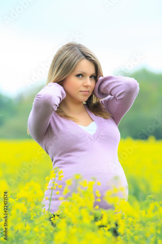 Schwangere Frau im Rapsfeld