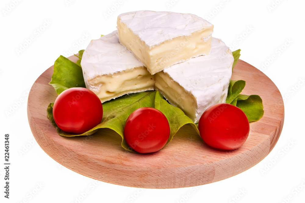 Round camembert cheese on wooden board.