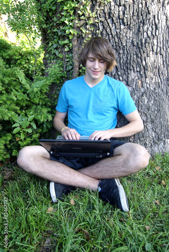 Long Hair Teen Boy with Laptop Sitting photo