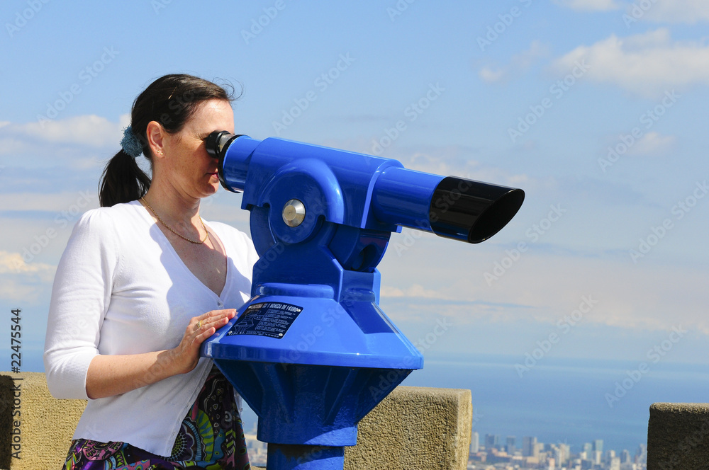 Woman looking through a coin operated binoculars