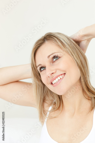 Happy woman stretching on her bed