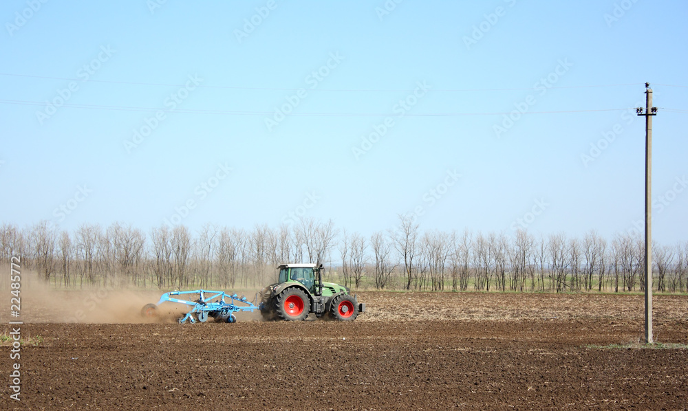 Obraz premium The tractor processes the earth