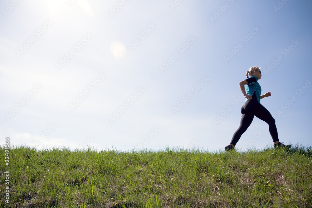 Young woman running outdoors on green trail Young woman running outdoors on green trail