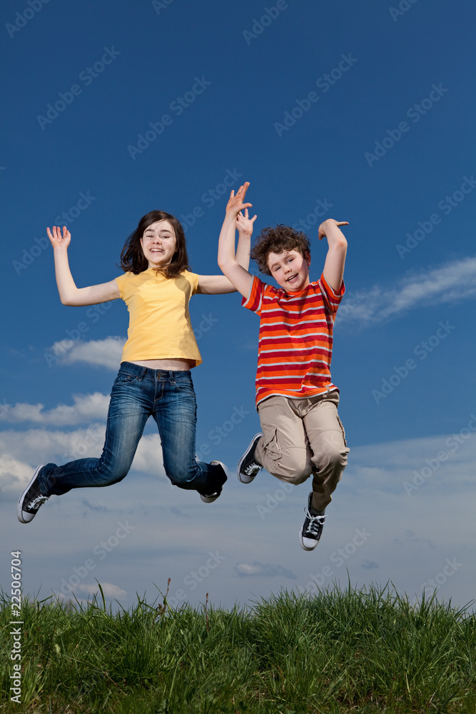 Girl and boy jumping, running against blue sky Girl and boy jumping, running against blue sky