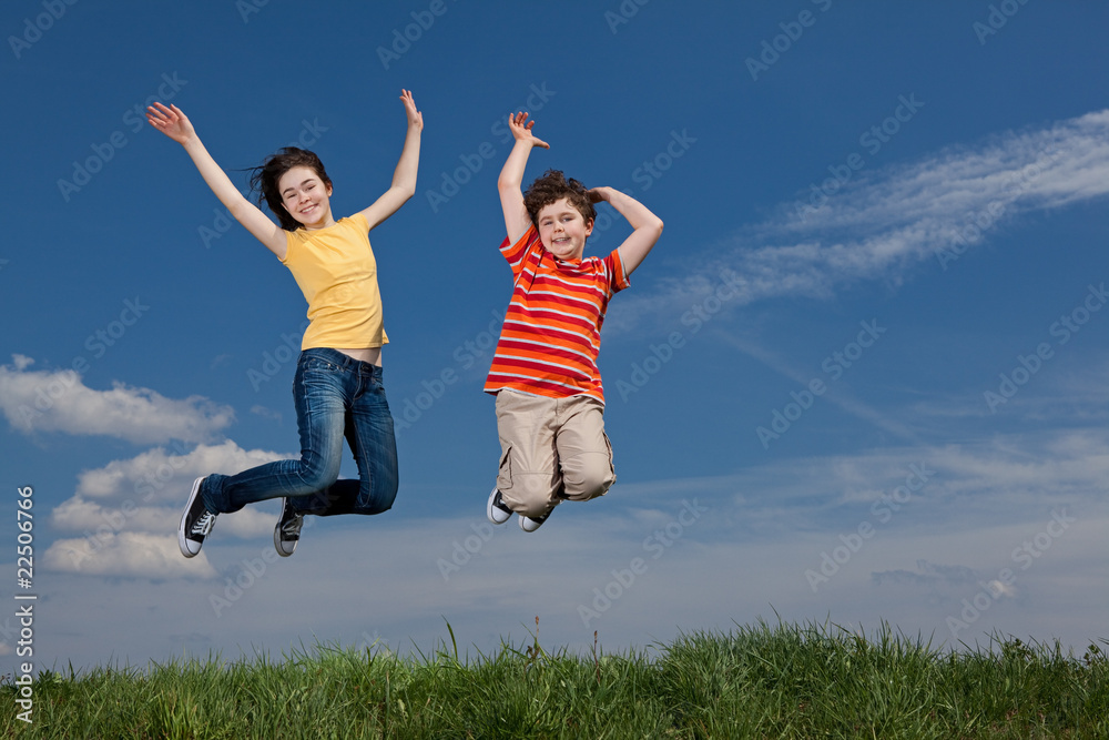 Girl and boy jumping, running against blue sky Girl and boy jumping, running against blue sky