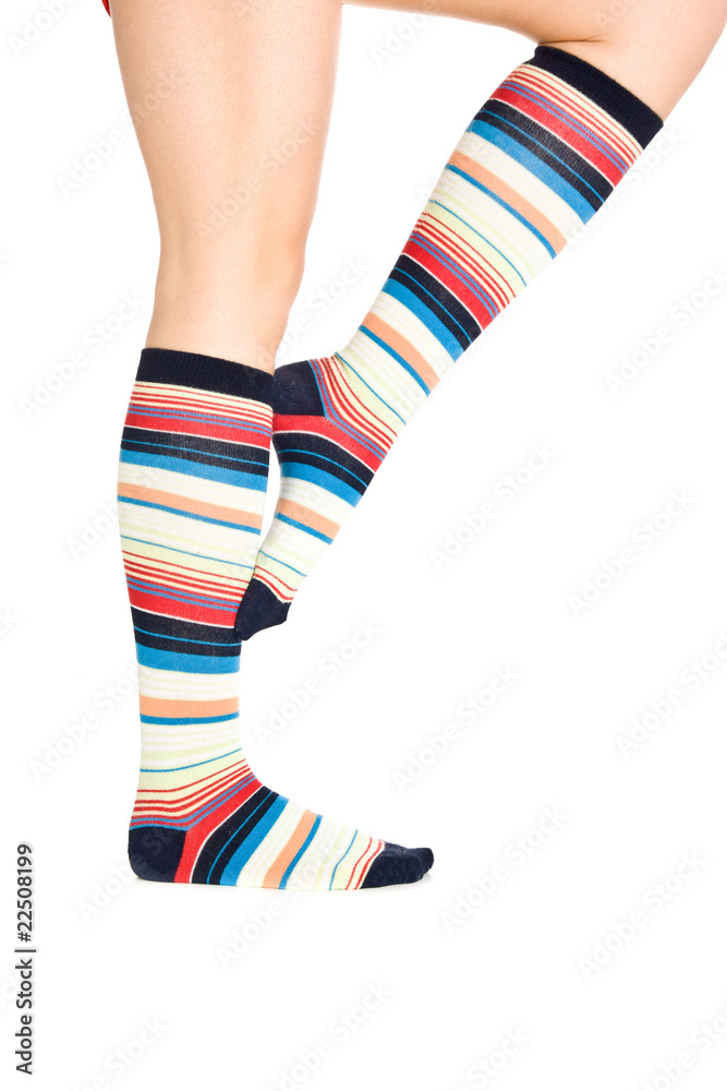 Caucasian woman legs in colorful stripped socks on white isolate Caucasian woman legs in colorful stripped socks on white isolate