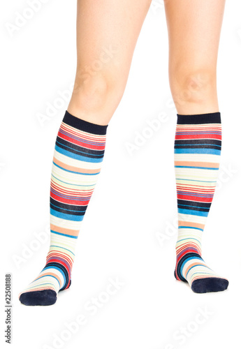 Caucasian woman legs in colorful stripped socks on white isolate