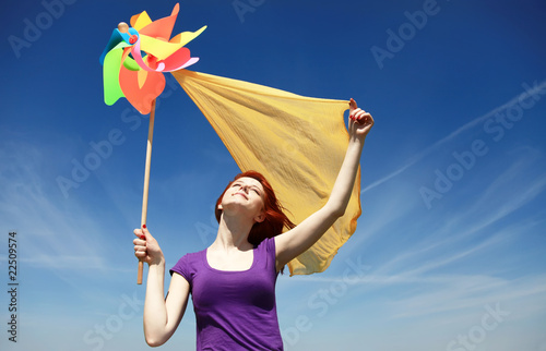 Young girl with wind turbine and silk at rape field.