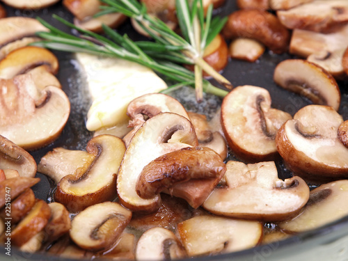 cooking mushrooms, butter & herb in a black pan