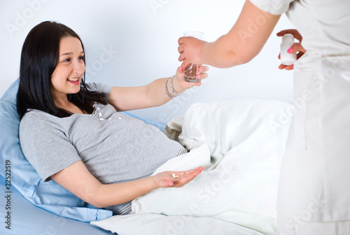 Pregnant woman taking  vitamins in hospital