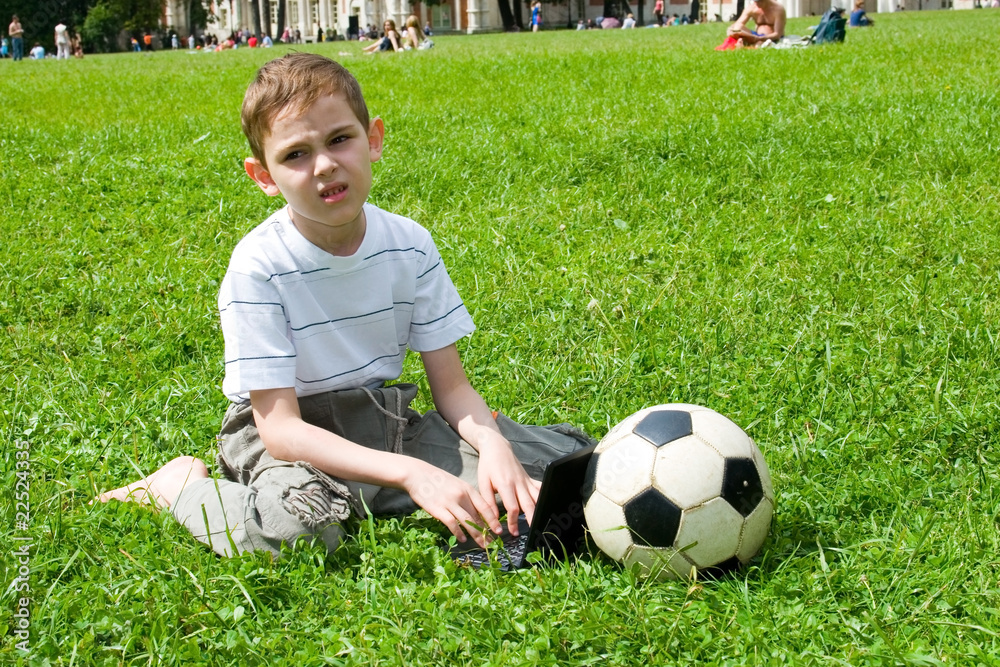 Obraz premium Boy with a laptop and a soccer ball