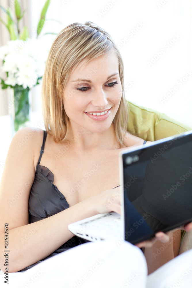 Serious Caucasian woman surfing the internet sitting on a sofa