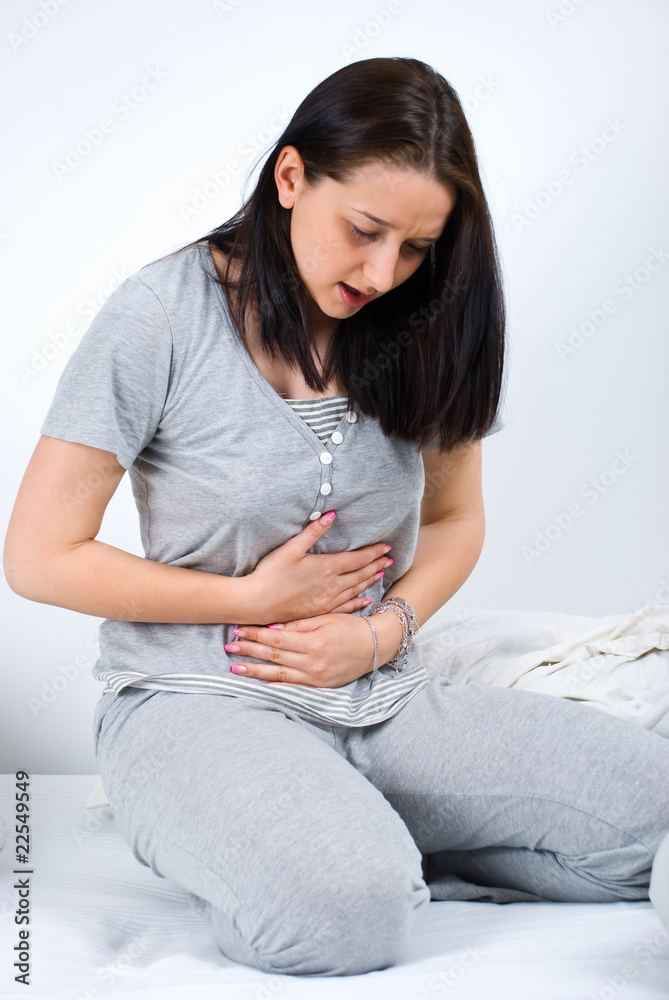Obraz premium Woman stomachache in bed