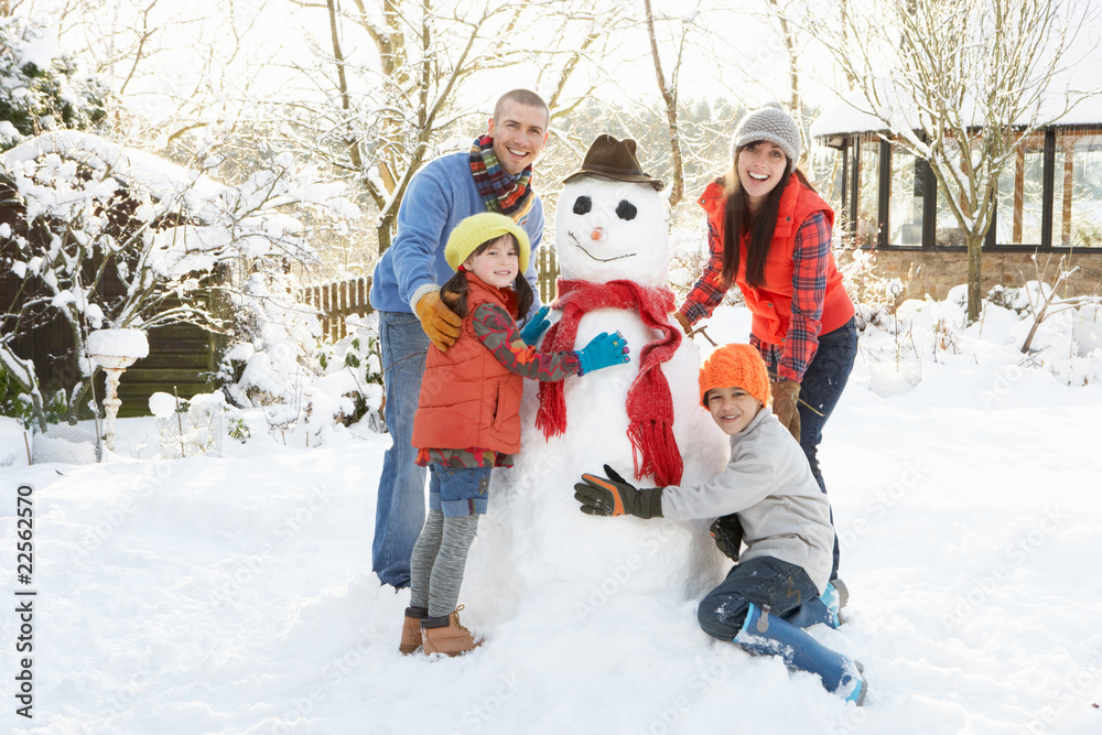 Family Building Snowman In Garden Family Building Snowman In Garden