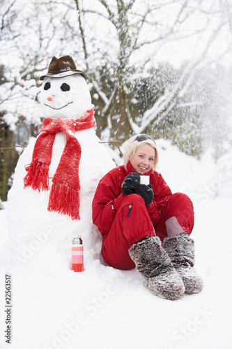 Teenage Girl Next To Snowman With Flask And Hot Drink