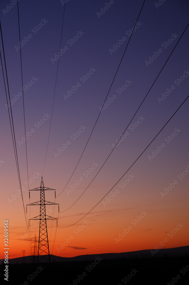 Electricity transfer lines and pylon in sunset