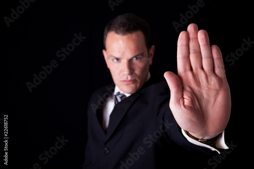 Businessman with his hand raised in signal to stop