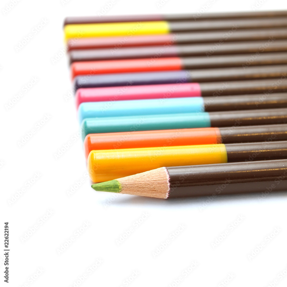 Colored pencils and a unique green on a white background Colored pencils and a unique green on a white background
