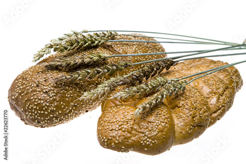 Wheat and bread on white background
