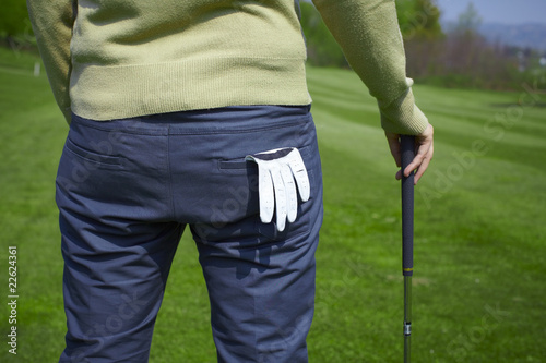 Golfer from the back with glove and holding golf club
