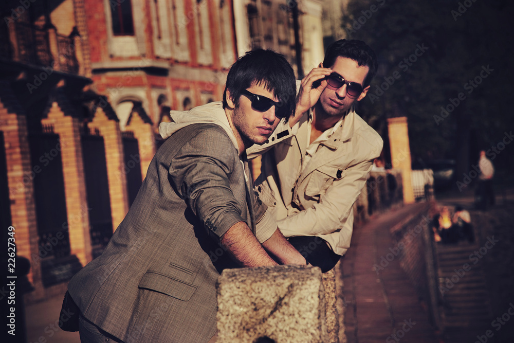 Two handsome friends posing on a city promenade Two handsome friends posing on a city promenade