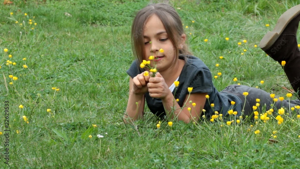 fillette composant un bouquet de boutons d'or