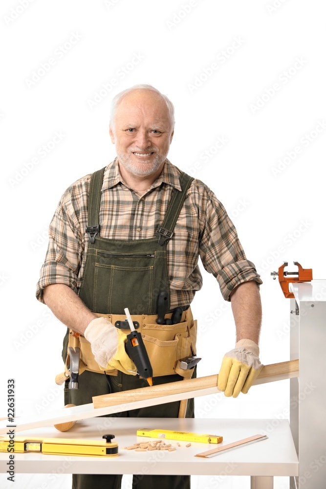 Cheerful elderly man tinkering Cheerful elderly man tinkering