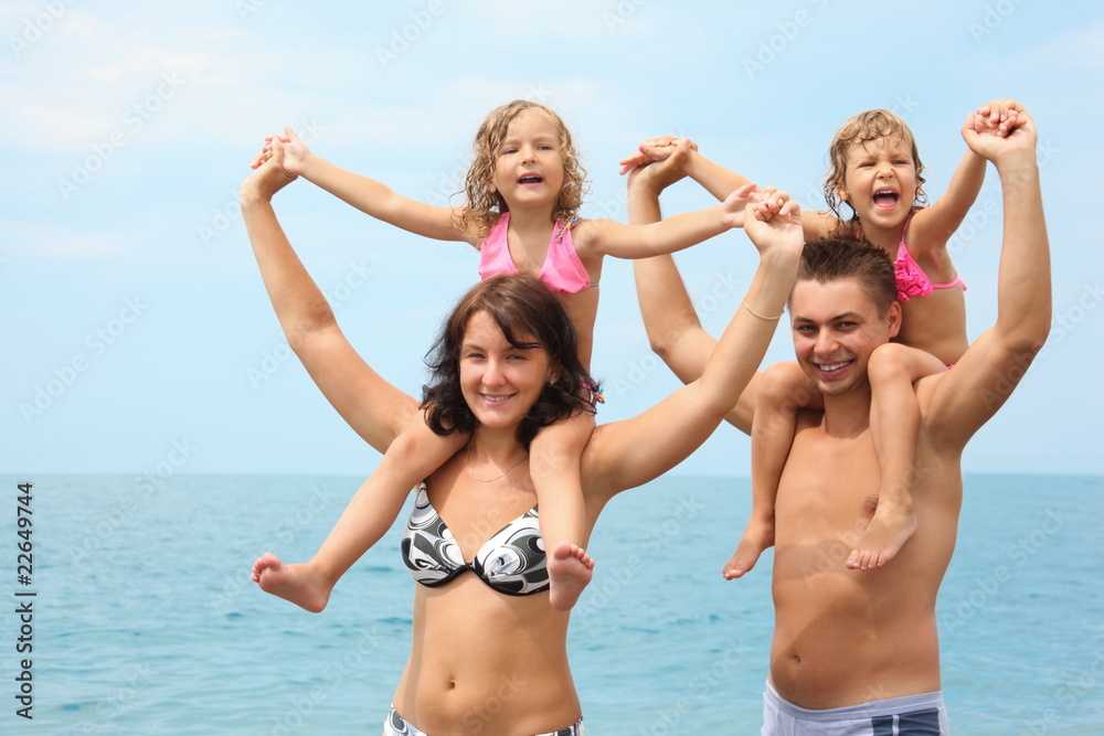 parents near water with little girls sitting on necks handies parents near water with little girls sitting on necks handies