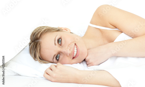 Cheerful woman relaxing lying on a bed