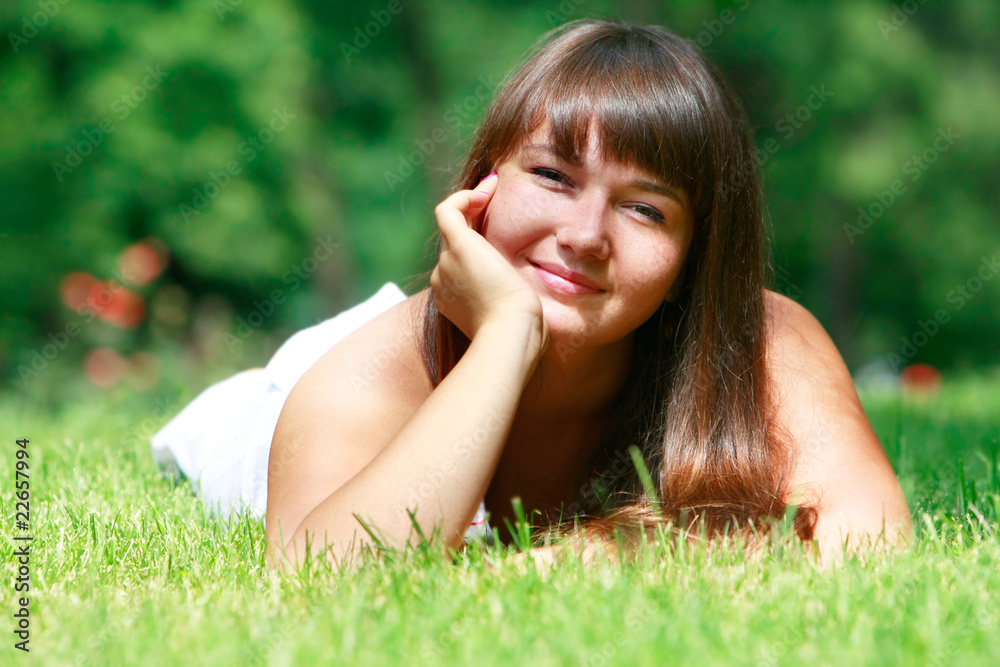 happy young girl relaxing in green grass