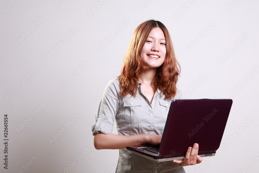 Laughing woman using a laptop against a white background . Laughing woman using a laptop against a white background .