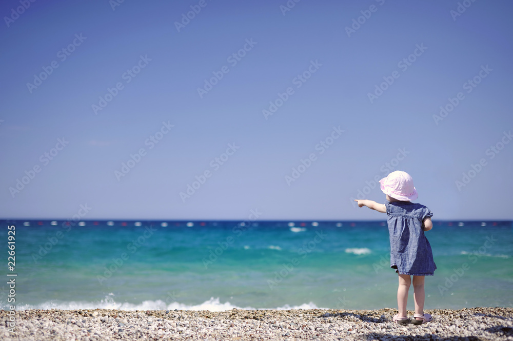 Adorable girl on a pebble beach