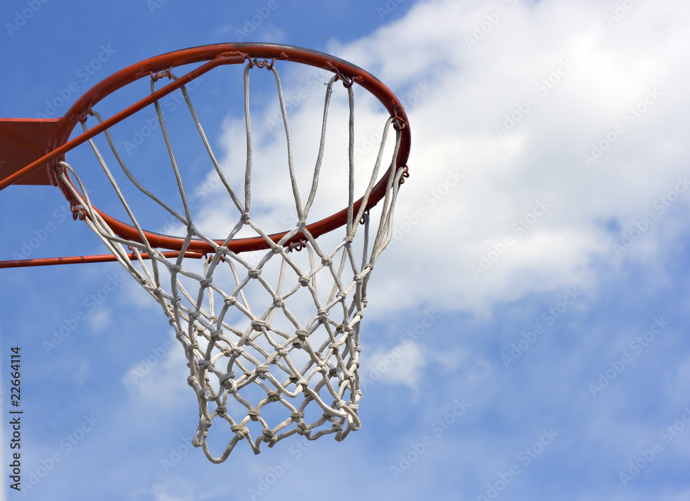 An orange basketball hoop against a blue sky