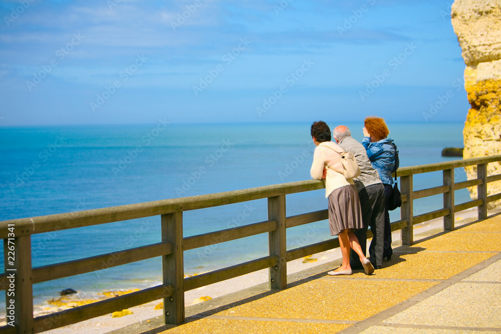 3 personnes regardent la mer