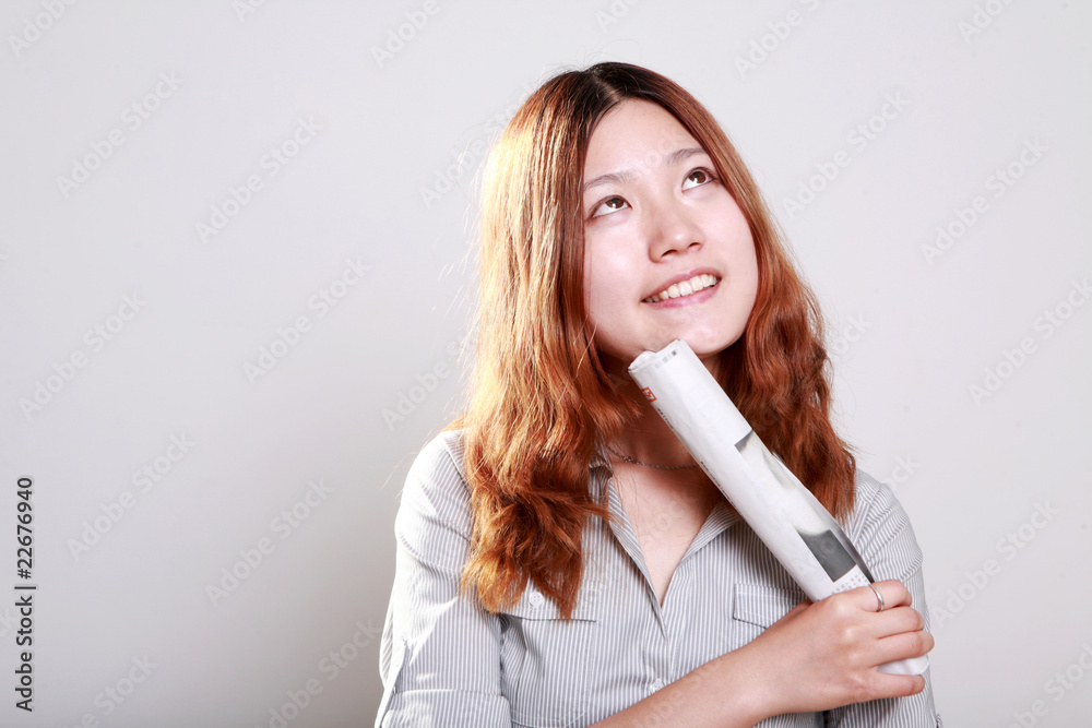 A beautiful smiling woman holding a rolled newspaper A beautiful smiling woman holding a rolled newspaper