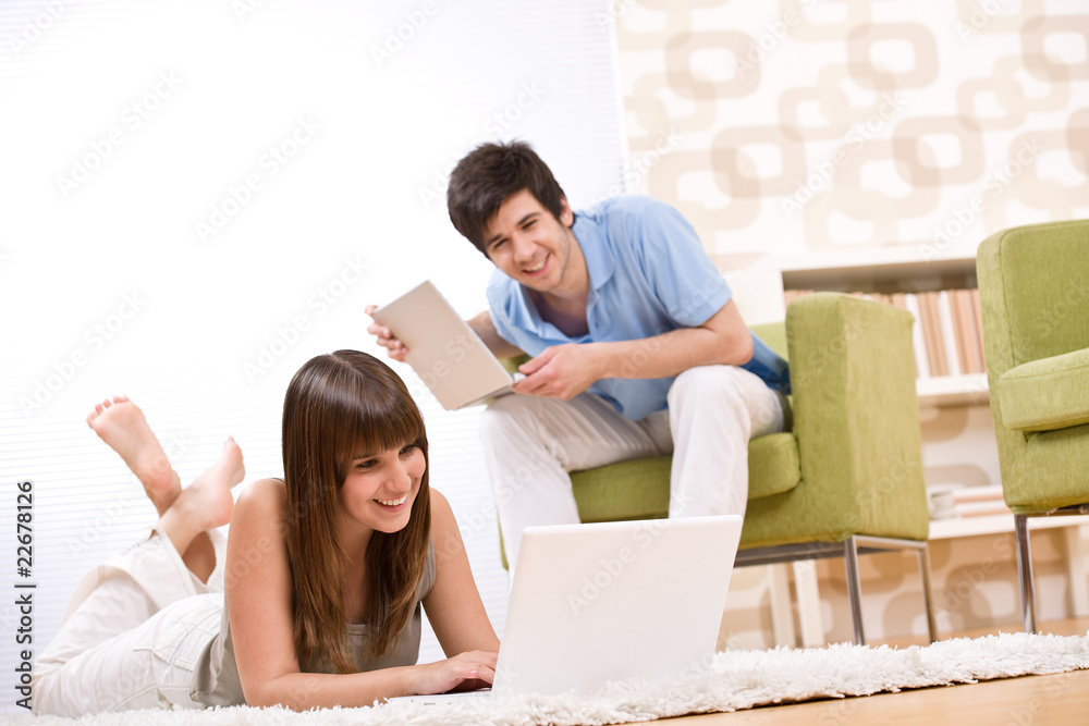 Student - two teenager with laptop in living room Student - two teenager with laptop in living room